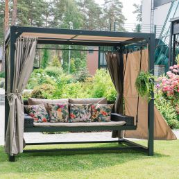 Brown and beige garden swing with a metal frame and removable curtains. Comes with multicolored cushions.