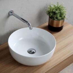 Valkoinen, pyöreä päälle asennettava allas, halkaisija 390 mm, esillä puutasolla, viereisessä kupariruukussa vihreä kasvi.