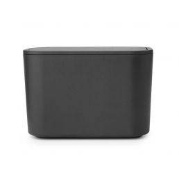 Musta jätteenkeräysastia, minimalistinen muotoilu, pehmeät reunat ja mattapinta.