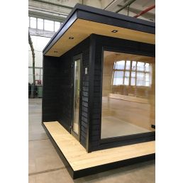 Liten bastu med svart träpanel, stora glasfönster och en modern design.