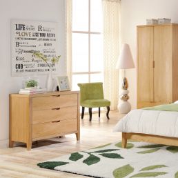 Lipasto 'CHAMBA', mitat 90x45x75 cm, tammiviimeistely. Huoneessa on myös vihreä tuoli, vaalea sänky ja matto.