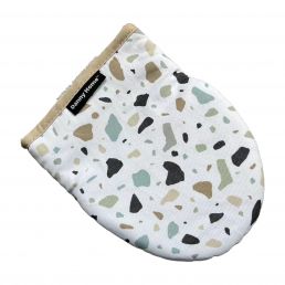 Vit oval grytlapp med ett flerfärgat terrazzo-mönster och en ljusbrun kant.