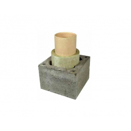 Square base made of grey concrete blocks with light brown cylindrical chimney liner parts inside.