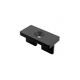 Musta suorakulmainen muovikiinnike, koko 18x36x12 mm, keskellä kartiomainen aukko ja alla kaksi jalkaa.