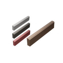 Four rectangular concrete curbstones in different colors and sizes on a white background.