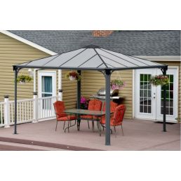 Pergola med metallram och glastakpaneler, svart ram. Dimensioner 3,6x3,6 m, installerad på en terrass med bord och stolar.