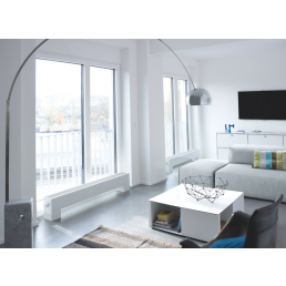 Valge radiaator Stana, mõõtmetega 150x600 mm, paigaldatud valgusküllasesse ja modernsesse elutuppa suurte akendega.