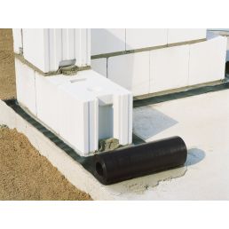 Valge niiskuse isolatsioonilint müürile, rullis, mõõtmed 25m x 280g/m², kõrval must toru ja seinaplokid.