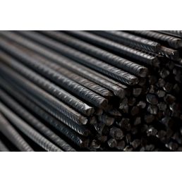Black steel rebar rods with a ribbed surface, in a round shape, bundled together. Each rod is 6 meters long and 5-20 mm thick.