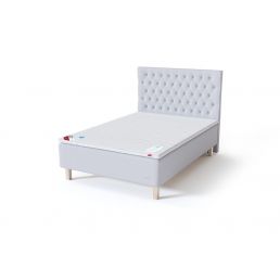 White daybed with a high, quilted headboard design and dark legs. Available in widths ranging from 80 to 140 cm.