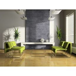 En vägg täckt med ljusgrå dekorativ sten, prydd med två moderna gröna fåtöljer och ett vitt soffbord. Rummet har också stora fönster och trägolv.