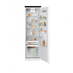 Valge integreeritav külmik avatud uksega, nähtavad on mitu riiulit ja sahtlit, täidetud jookide ja toiduainetega.