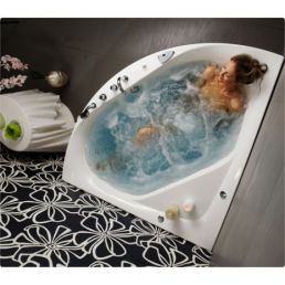 Valge nurgaga massaaživann, mis on täidetud veega ja mullidega, küünlad põlevad serval.