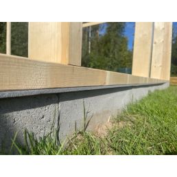 Moisture barrier for wooden constructions, suitable for walls of 125-250 mm. Gray, even surface next to green grass.