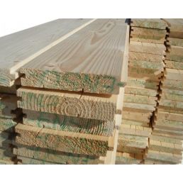 Staplade granträgolvbrädor i olika storlekar, med synliga årsringar och detaljrik textur.