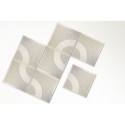 Set of four white perforated acoustic panels with wavy, geometric patterns.