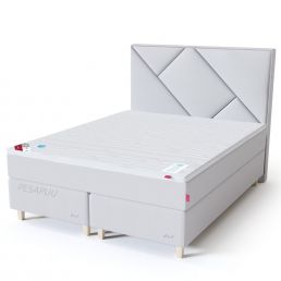 White continental bed with red and blue buttons. Geometric headboard, base with two drawers.