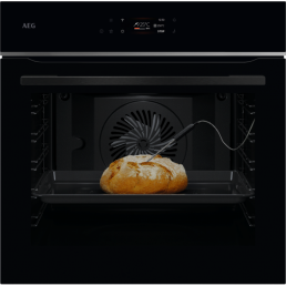 Integrated black oven with a digital display and fan, featuring a loaf of bread baking inside.