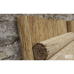 Dense reed mat, measuring 1.8 x 6 meters, set against a gray stone wall background.
